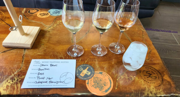 Three numbered tasting glasses beside a handwritten wine list at Accent Cellars